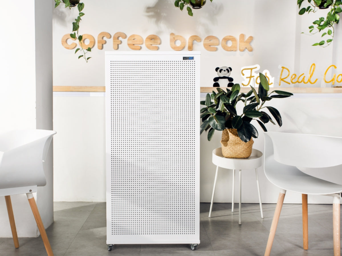Smart Air Blast air purifier in a modern cafe or office setting with 'Coffee Break' sign and plants.