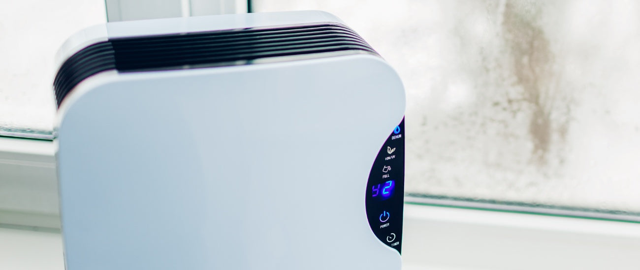 White Dehumidifer Air Purifier Combo Unit with condensation on window in background