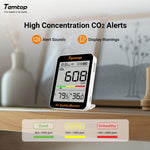 Temtop air quality monitor displaying CO2 levels on a wooden surface with a blurred indoor background.