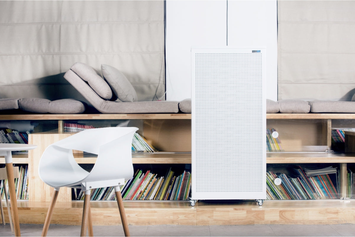 Smart air Blast air purifier on a shelf in a room with books and a chair