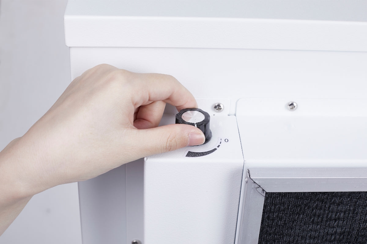 Hand adjusting the speed dial on a Smart Air blast air purifier
