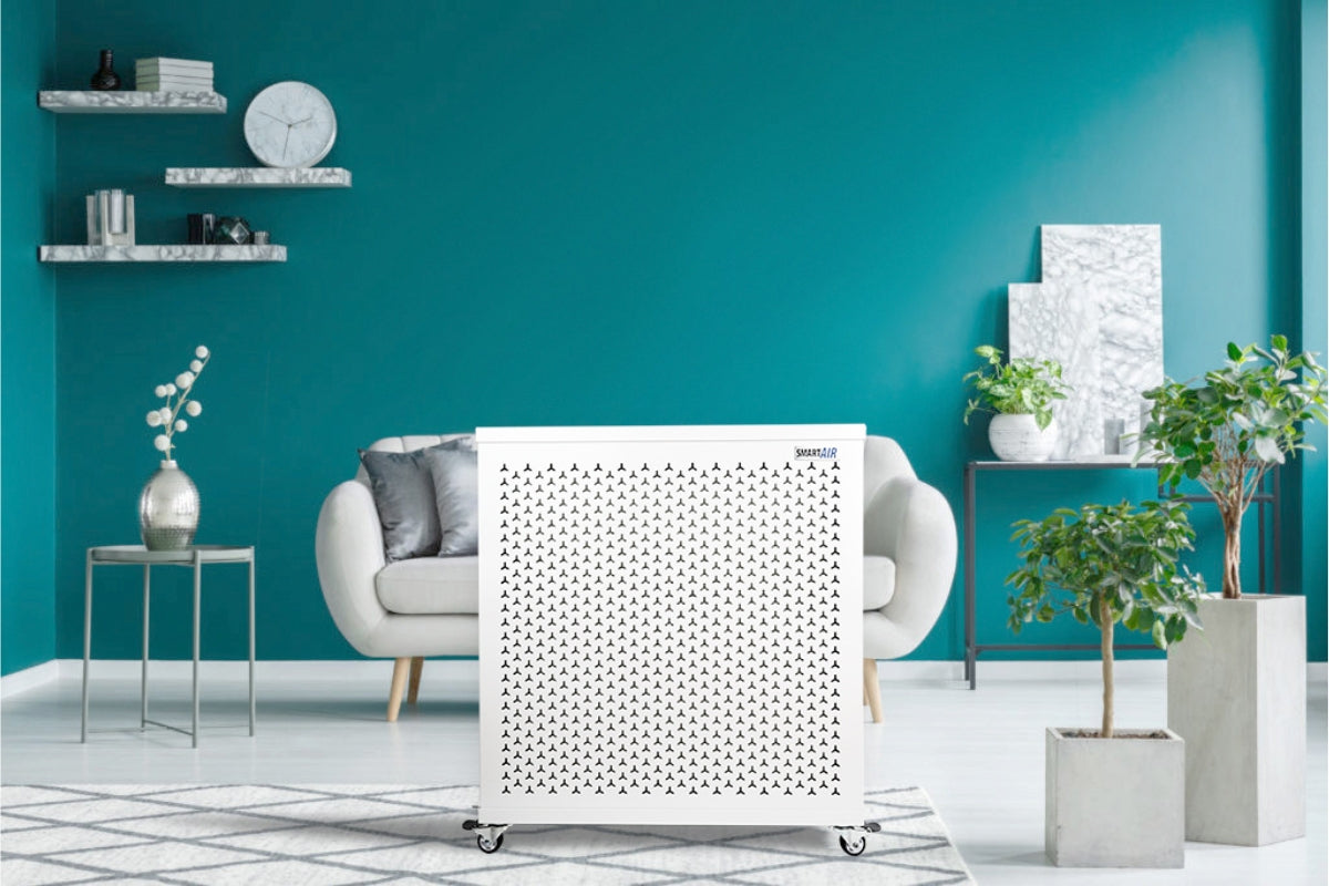 Smart Air blast mini air purifier in a modern living room with teal walls and decorative elements.