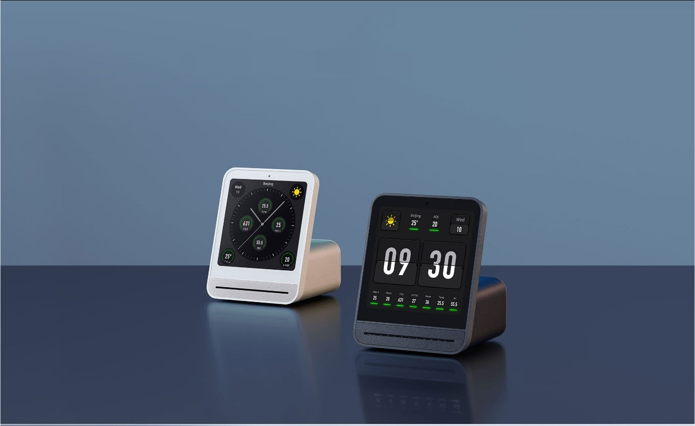 Qingping Pro 2 Air quality monitors on a reflective surface with a blue gradient background