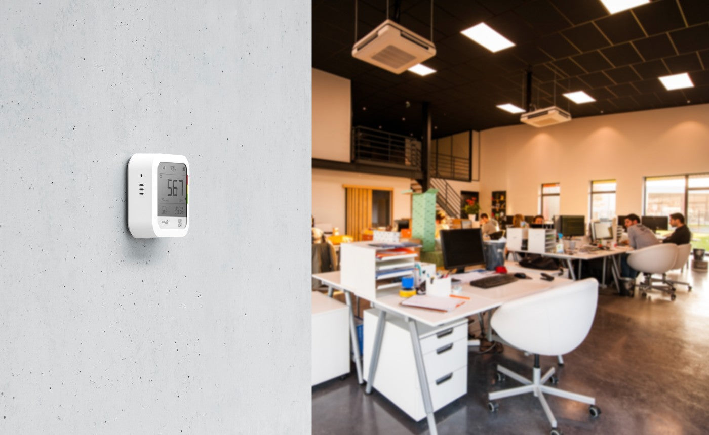 Smart Air CO2 monitor on concrete wall with office in the background