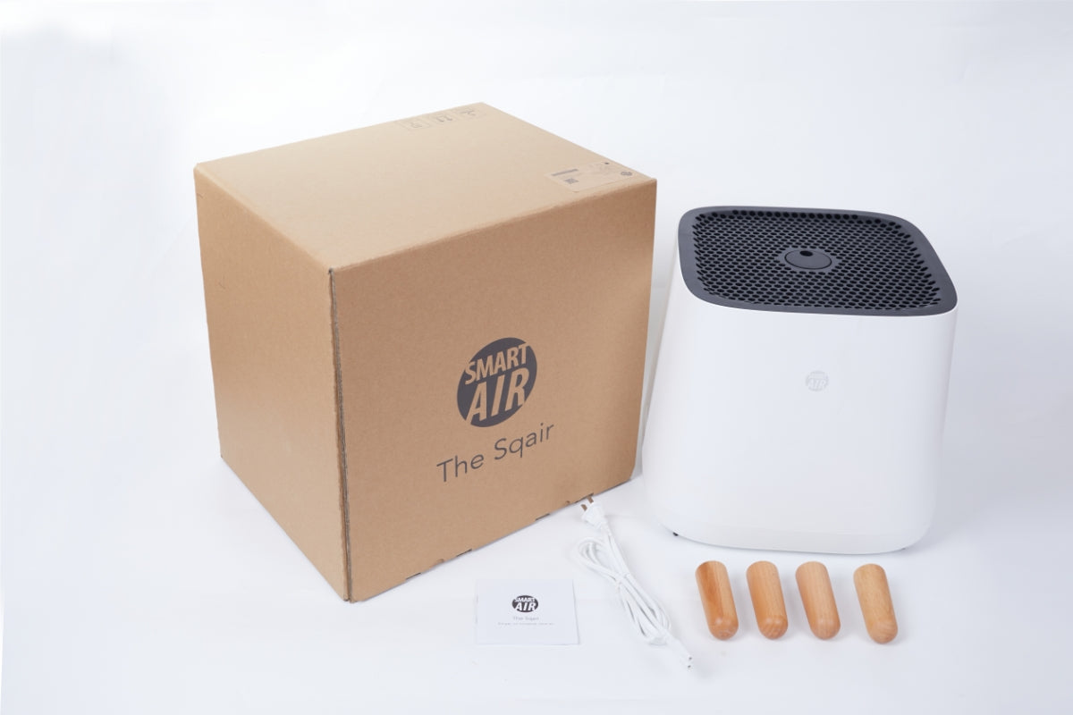 Smart Air Sqair air purifier with legs detached and brown box labeled 'Smart Air The Sqair' on a white background