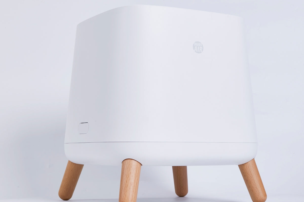 Smart Air Sqair air purifier with wooden legs on a light grey background