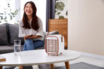 Smart Air QT3 portable Air Purifier on white table with woman smiling in the background