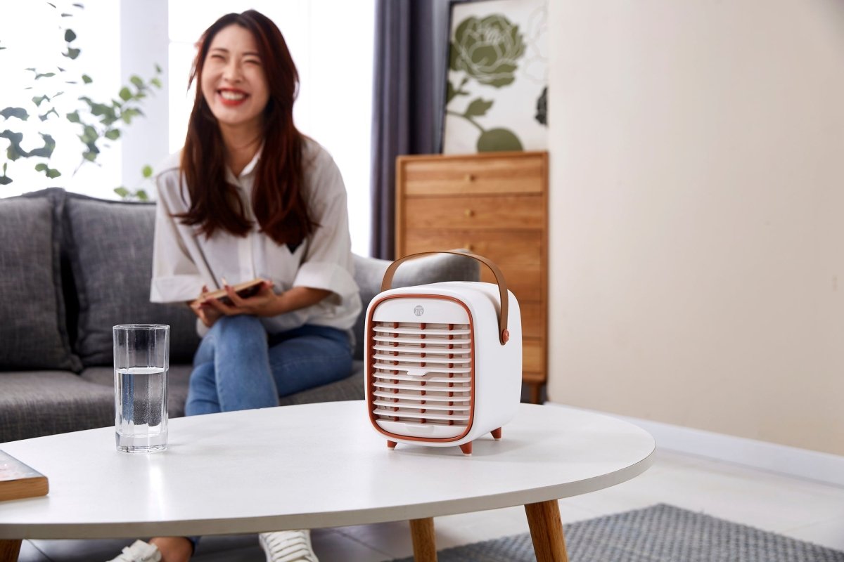 Smart Air QT3 portable Air Purifier on white table with woman smiling in the background
