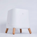 Side front view of Smart Air Sqair air purifier with wooden legs on light grey background